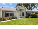 Front entrance with walkway and manicured lawn at 26030 Newcombe Cir, Leesburg, FL 34748