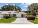 House exterior with a two-car garage and driveway at 26030 Newcombe Cir, Leesburg, FL 34748