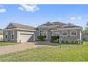 Property front view with a large lawn and paved driveway at 310 Lake Mariana Pl, Auburndale, FL 33823
