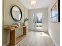 Bright entryway with wood console table and large circular mirror at 3221 Arch Ave, Ormond Beach, FL 32174