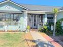 Inviting entryway with a secure wrought iron gate and lush tropical landscaping at 3250 Dellbrook Dr, Deltona, FL 32738