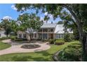 House with metal roof, circular driveway, and lush landscaping at 3413 Lilas Ct, Windermere, FL 34786