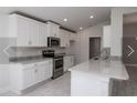 Modern kitchen featuring white cabinets, granite countertops, and stainless steel appliances at 4284 Sagefield Drive, St Cloud, FL 34773