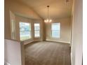 Bright dining room features a tray ceiling, chandelier, and large windows offering ample natural light at 4306 Sagfefield, St Cloud, FL 34773