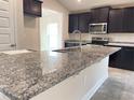 Modern kitchen boasts granite countertops, stainless steel appliances, and dark brown cabinetry at 4306 Sagfefield, St Cloud, FL 34773