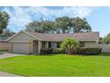 Landscaped one story house with gray siding, attached garage, and spacious yard at 5405 Justine Way, Winter Park, FL 32792