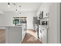Bright kitchen featuring stainless steel appliances, a large island, and modern pendant lighting at 105 Marion Oaks Manor, Ocala, FL 34473