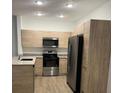 Modern kitchen with stainless steel appliances and light wood cabinets at 1230 Southstation Pl # 105, Orlando, FL 32809
