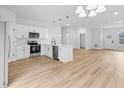 Modern white kitchen with stainless steel appliances and island at 15410 Sw 23Rd Court R, Ocala, FL 34473