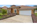 Front view of house with driveway, landscaping, and white garage door at 1943 Sipes Ave, Sanford, FL 32771
