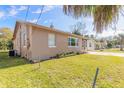 Side view of tan house, showcasing a well-maintained lawn at 421 Jefferson St, Daytona Beach, FL 32114