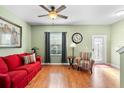 Living room with hardwood floors, red couch, and access to backyard at 4847 Havilland Dr, Mount Dora, FL 32757