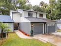 Two-story townhome with gray siding, gray garage door, and landscaped walkway at 844 Sugar House Dr, Port Orange, FL 32129