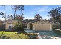 Single-story house with a green door and attached garage, surrounded by a yard at 95 Fort Smith Blvd, Deltona, FL 32738