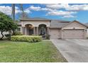 Two-story house with a large driveway and landscaped front yard at 11013 Creighton Dr, Orlando, FL 32817