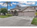 Two-story house with a large driveway and landscaped front yard at 11013 Creighton Dr, Orlando, FL 32817