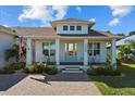 Charming house with a light blue front door, rocking chairs on the porch, and well-maintained landscaping at 1406 Saxon Dr, New Smyrna Beach, FL 32169