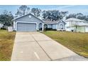 House with a gray facade, driveway, and landscaped yard at 15824 Marsh Elder St, Clermont, FL 34711