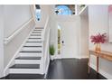 Bright entryway with staircase, dark hardwood floors, and a view to the backyard at 1763 Stargazer Ter, Sanford, FL 32771