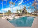 Inviting pool and spa with a screened enclosure and lake views at 2224 Alaqua Dr, Longwood, FL 32779