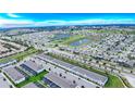 Wide aerial view of a residential community, featuring multiple houses and a lake at 2432 Dubai St, Kissimmee, FL 34747