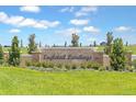 Landscaped entrance sign for Eagletail Landings featuring stone accents and manicured greenery under a sunny sky at 27469 Black Kite Ave, Howey In The Hills, FL 34737
