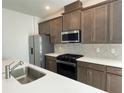 Well-appointed kitchen showcasing a large island, stainless steel appliances, and stylish backsplash at 27469 Black Kite Ave, Howey In The Hills, FL 34737