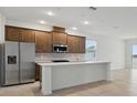Bright, open kitchen featuring stainless steel appliances, modern white counters, and tile flooring at 27469 Black Kite Ave, Howey In The Hills, FL 34737