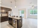 Modern kitchen with dark cabinetry, granite countertops, stainless steel appliances, and island at 3196 Crown Jewel Ct, Winter Park, FL 32792