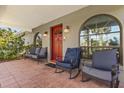 Inviting front porch with comfortable seating, decorative accents, and arched windows at 36129 E Eldorado Lake Dr, Eustis, FL 32736