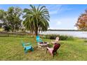 Lakefront backyard with fire pit and colorful Adirondack chairs at 41235 Silver Dr, Umatilla, FL 32784