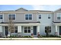 Two-story light blue townhome with gray accents and landscaping at 627 Bayhawk St, Debary, FL 32713