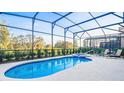 Enclosed pool and spa with lounge chairs; backyard oasis at 7619 Oakmoss Sw Loop, Davenport, FL 33837