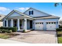 Two-story home with light blue siding, two-car garage, and a neatly landscaped front yard at 8547 Bayview Crossing Dr, Winter Garden, FL 34787