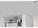 Bright kitchen with gray cabinets, granite countertops, and stainless steel appliances at 1343 Foran Manor Rd, Haines City, FL 33844