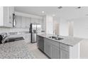 Modern kitchen with gray cabinets, granite countertops, and stainless steel appliances at 1343 Foran Manor Rd, Haines City, FL 33844