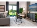 Living room with gray couch, two nesting coffee tables, and sliding glass doors at 1343 Foran Manor Rd, Haines City, FL 33844