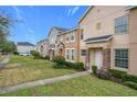 Row of townhouses with green lawns, sidewalks, and American flags at 13651 Eridanus Dr, Orlando, FL 32828