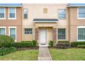 Townhouse entrance with stone accents, a white door, and manicured landscaping at 13651 Eridanus Dr, Orlando, FL 32828