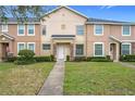 Two-story tan townhome with stone accents and a neatly landscaped yard at 13651 Eridanus Dr, Orlando, FL 32828