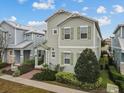 Two-story house with light green siding, brick walkway, and landscaping at 1472 Fairview Cir, Reunion, FL 34747