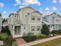 Two-story house with light green siding, brick walkway, and landscaping at 1472 Fairview Cir, Reunion, FL 34747