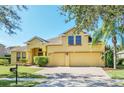 Two-story house with a two-car garage and lush landscaping at 1580 Prairie Oaks Dr, St Cloud, FL 34771