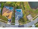Aerial view of a house with a screened in pool with mature landscaping at 1727 Wood Violet Dr, Orlando, FL 32824
