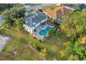 Aerial view of a home with a screened-in pool and lush green lawn at 1727 Wood Violet Dr, Orlando, FL 32824