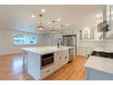 Modern white kitchen with stainless steel appliances and large island at 25335 Troon Ave, Sorrento, FL 32776