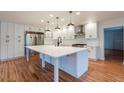 Modern kitchen with white shaker cabinets, large island, and stainless steel appliances at 25335 Troon Ave, Sorrento, FL 32776