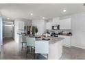 Open concept kitchen with granite island, white cabinets and stainless steel appliances at 3582 Fort Mellon Ln, Sanford, FL 32773