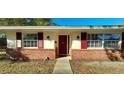 Welcoming front entrance with red door, red shutters, brick facade, and updated lighting at 4131 Yorketowne Rd, Orlando, FL 32812