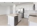 Open kitchen with stainless appliances, island, and view into the living space at 507 Silver Palm Dr, Haines City, FL 33844